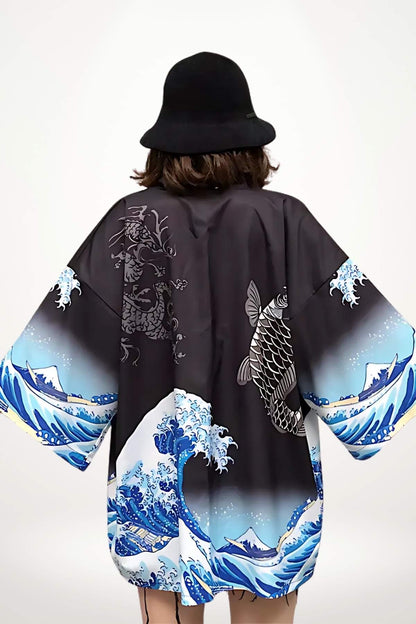 Kimono noir avec motifs de vagues et de poisson, porté par une femme au chapeau, sur fond blanc