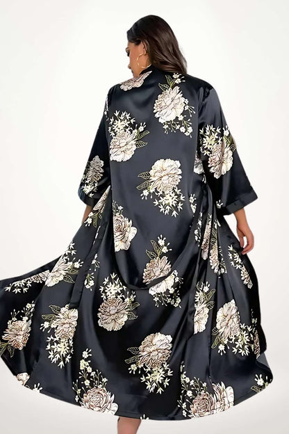 Kimono noir en satin avec des motifs floraux beiges, flottant élégamment dans un décor doux et apaisant