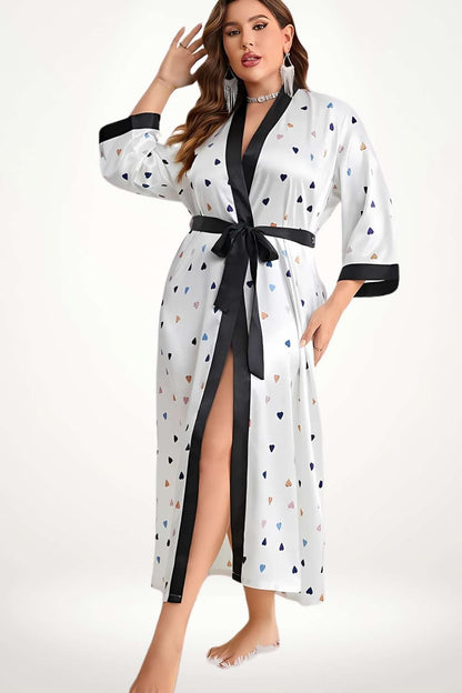 Kimono fluide blanc avec motifs en cœurs colorés, ceinturé de noir, porté par une femme en posture élégante