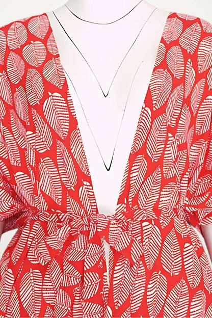 Kimono rouge à motifs de feuilles blanches, avec un décolleté en V et une ceinture nouée, sur fond neutre