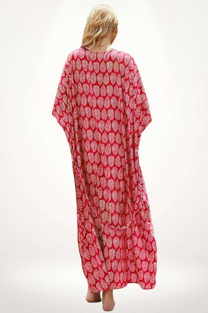 Femme vue de dos portant un kimono rouge à motifs de feuilles sur un fond clair, évoquant l'élégance estivale