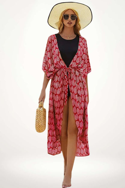 Femme en kimono rouge à motifs feuilles, portant un chapeau large et une pochette en osier, sur fond clair