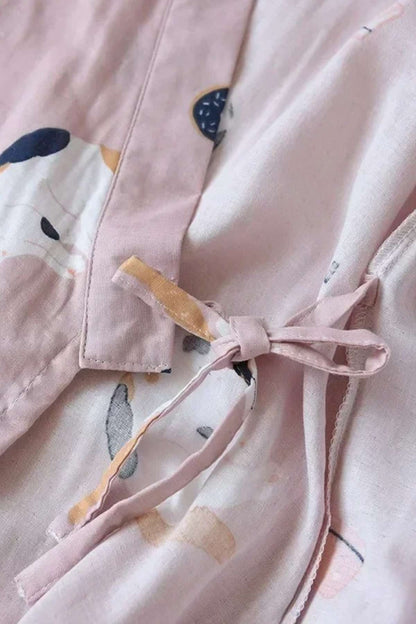 Détail d'un kimono en coton rose avec motifs colorés et un nœud délicat sur le côté