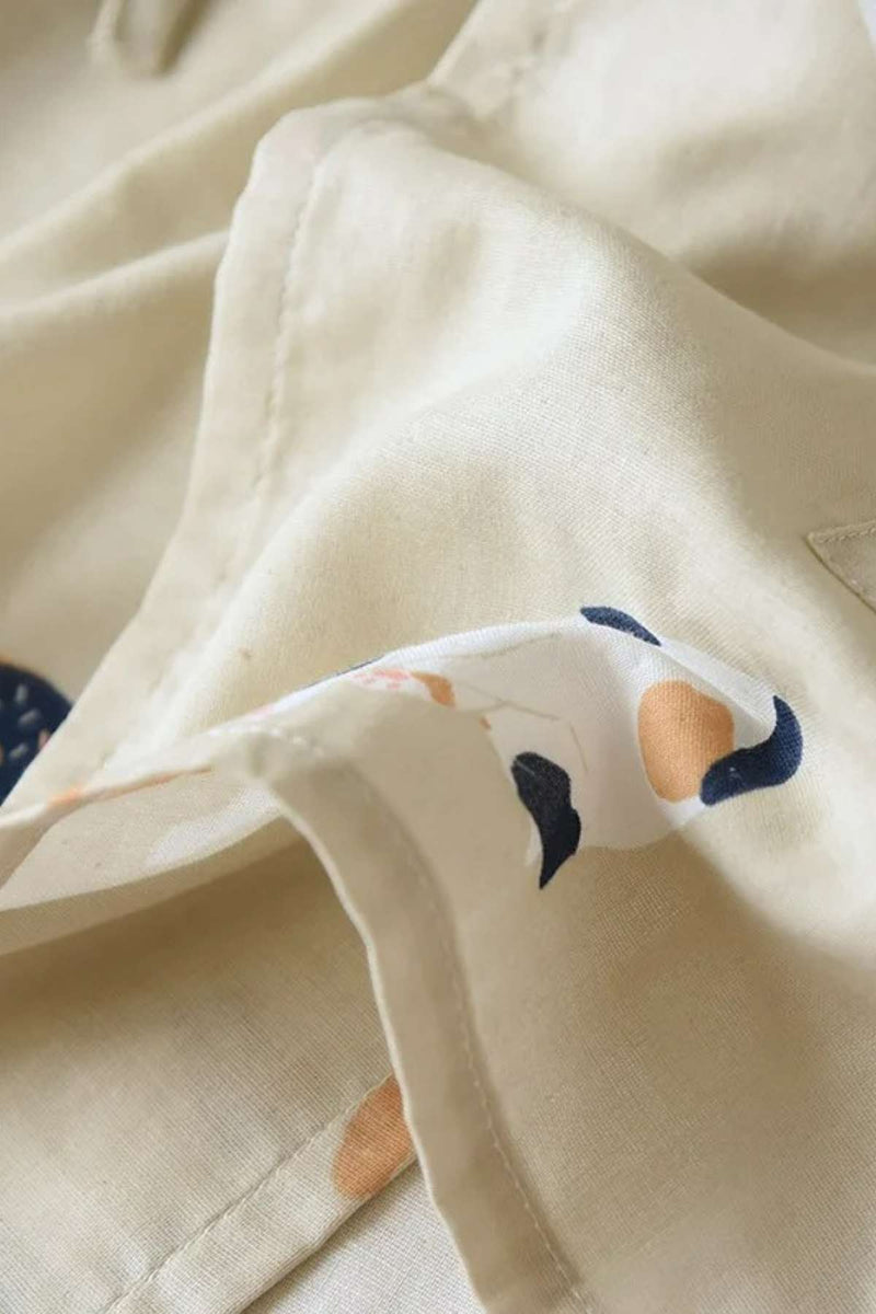 Tissu doux de couleur beige avec motifs floraux délicats en bleu et orange, plié élégamment