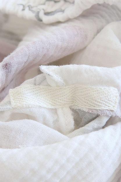 Tissu léger et doux en blanc, avec des motifs délicats, offrant une sensation de confort et de douceur