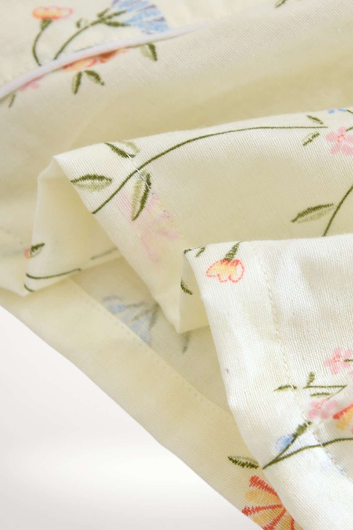 Tissu doux de couleur jaune clair avec motifs floraux délicats en rose et bleu, idéal pour un kimono confortable