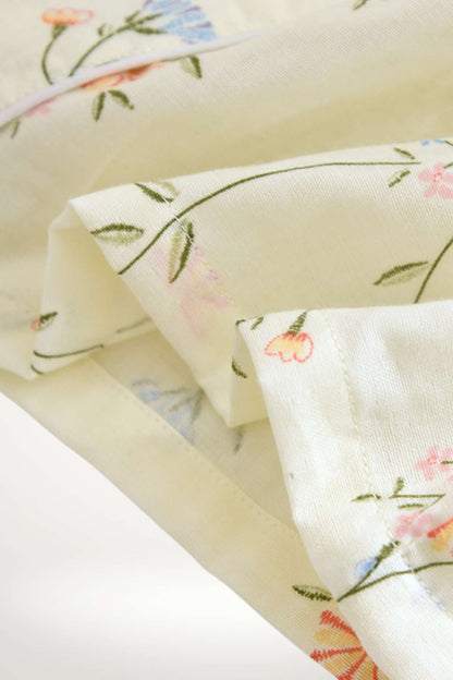 Tissu doux de couleur jaune clair avec motifs floraux délicats en rose et bleu, idéal pour un kimono confortable