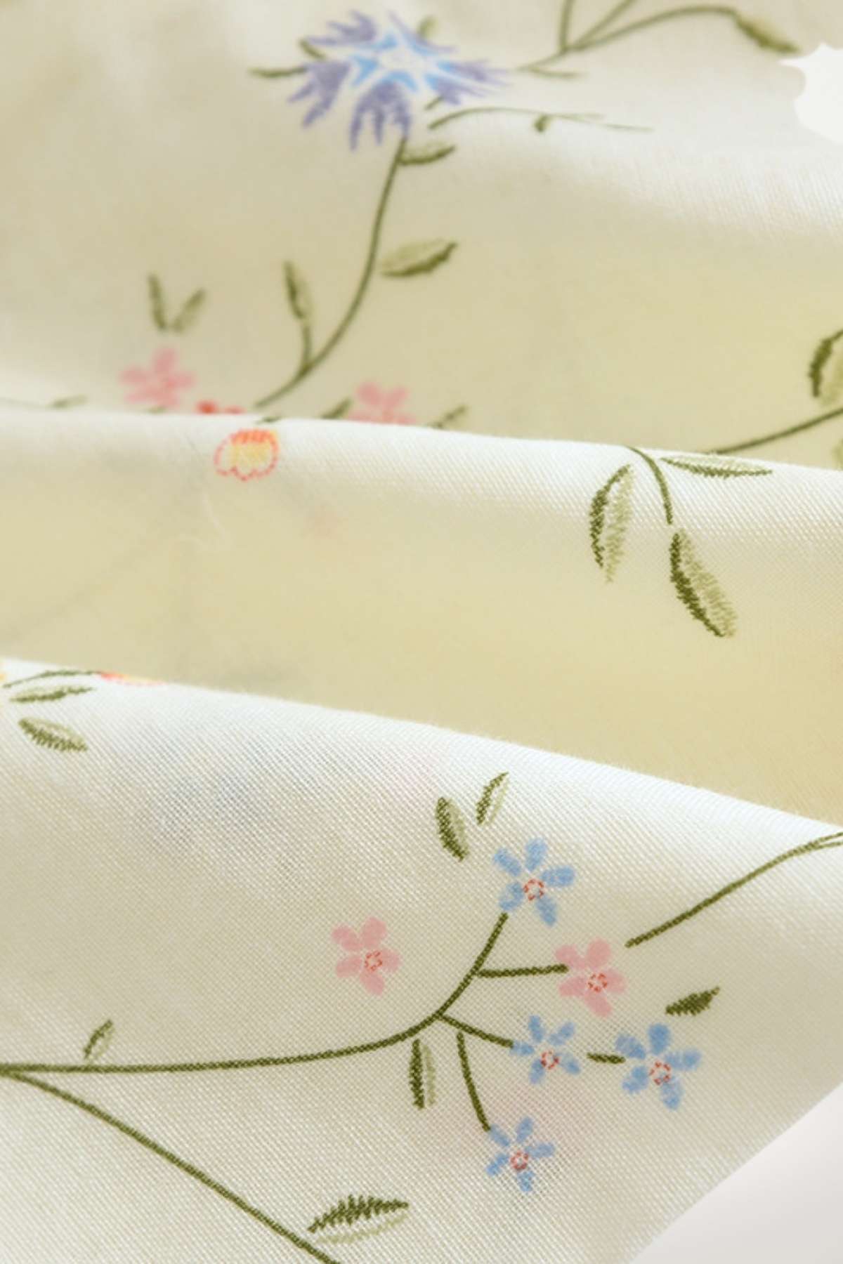 Tissu de kimono en satin crème orné de délicates fleurs bleues et roses sur fond vert