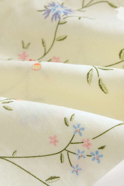 Tissu de kimono en satin crème orné de délicates fleurs bleues et roses sur fond vert