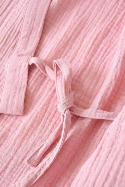 Détail d'un tissu en lin rose clair avec un nœud, évoquant un kimono confortable et élégant