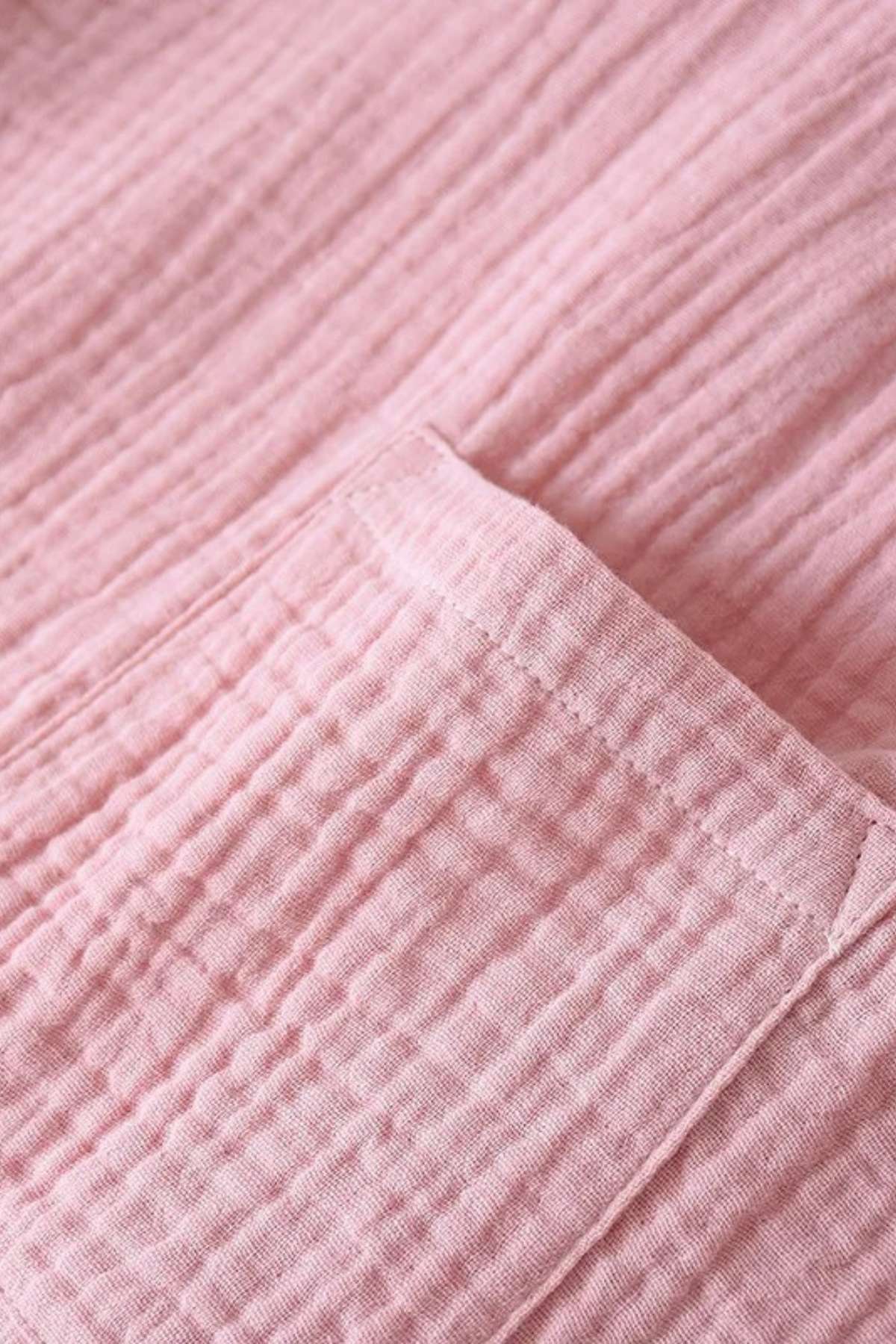 Tissu rose texturé avec des plis, mettant en avant un design doux et confortable pour un kimono de nuit
