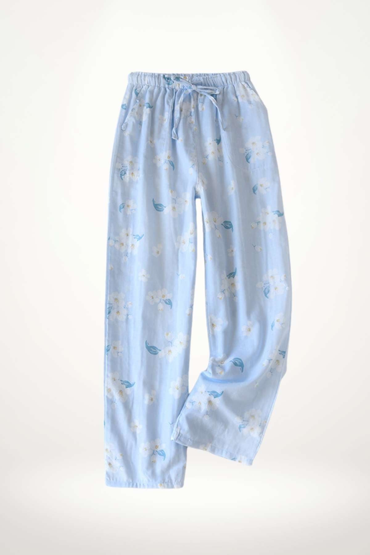 Pantalon léger en tissu bleu clair avec motifs floraux blancs et feuilles vertes, idéal pour un style épuré