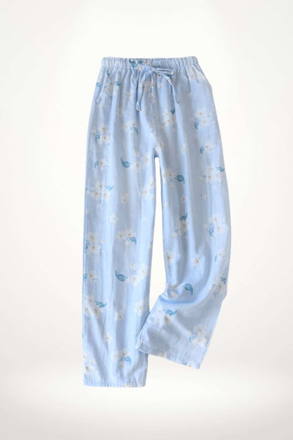 Pantalon léger en tissu bleu clair avec motifs floraux blancs et feuilles vertes, idéal pour un style épuré