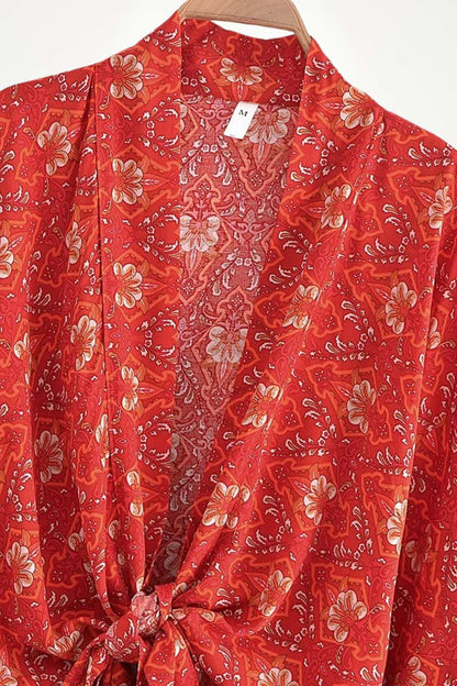 Kimono femme rouge à motifs floraux, en tissu léger, avec un nœud à la taille et un fond clair