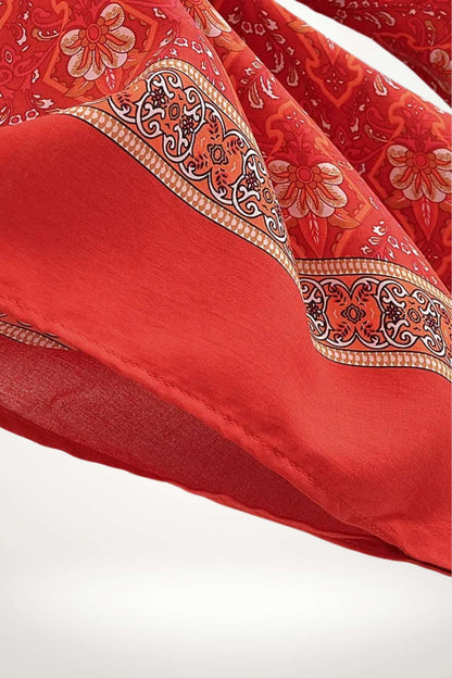 Tissu léger rouge avec motifs floraux et bordure ornée, évoquant un style japonais élégant et coloré