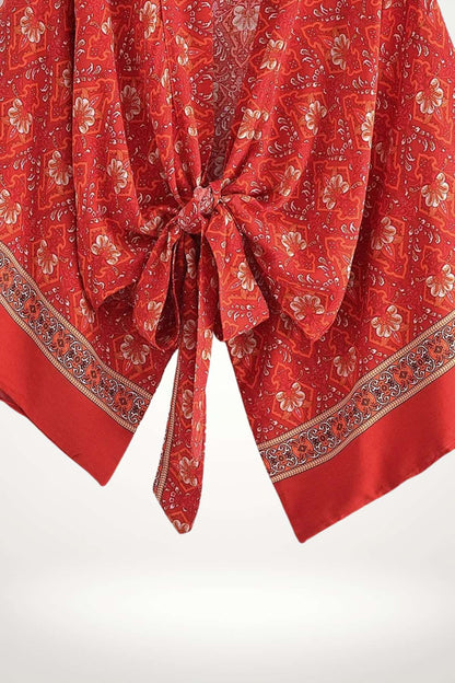 Kimono en tissu rouge à motifs floraux, avec un nœud central et une bordure décorative colorée