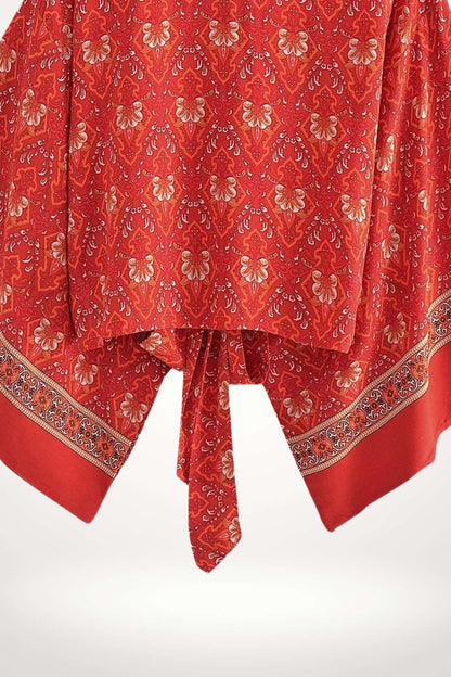 Un kimono rouge à motifs floraux, avec des détails en bordure, drapé élégamment sur un fond clair