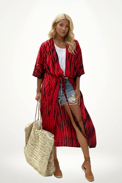 Femme portant un kimono rouge à motifs noirs, short en jean, avec un grand sac en osier