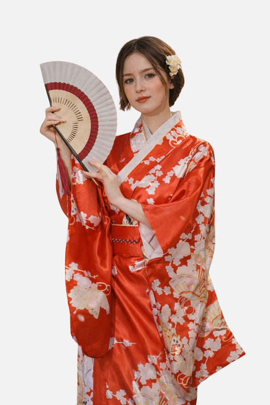 Femme en kimono rouge brillant avec motifs floraux, tenant un éventail, dans un décor minimaliste