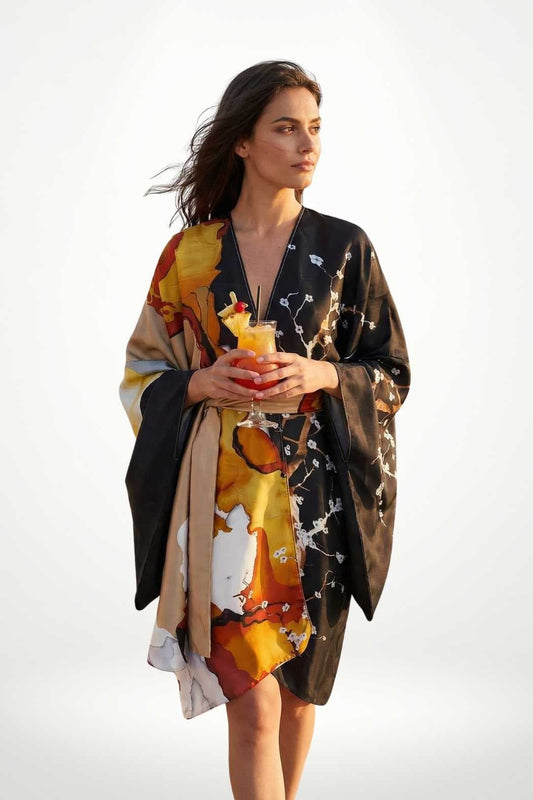 Femme en kimono satin aux motifs colorés, tenant un verre, avec un décor lumineux et aéré