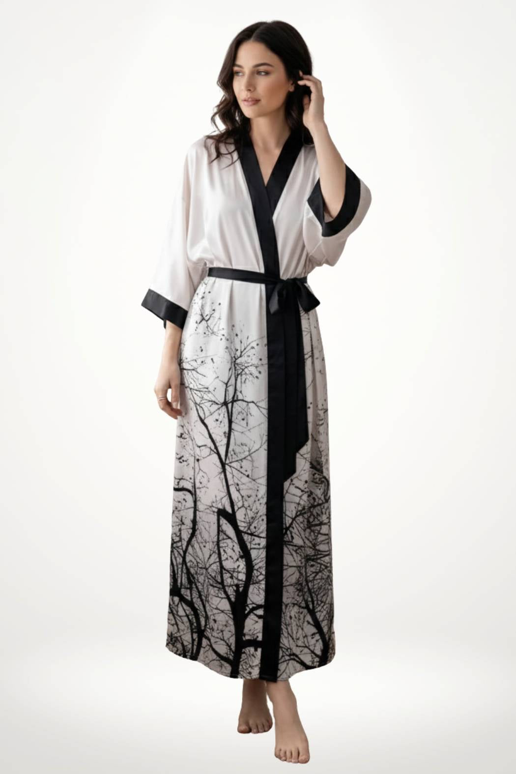 Kimono long en satin blanc avec motifs d'arbres noirs, ceinturé, porté par une femme aux cheveux ondulés