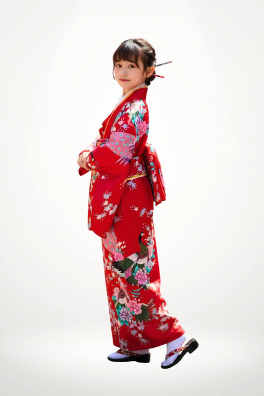 Fille portant un kimono rouge avec des motifs floraux colorés et un décor sobre en arrière-plan