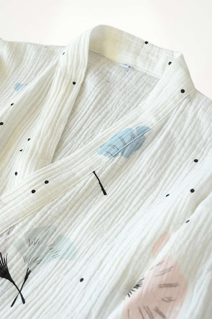 Kimono en gaze de coton blanc avec motifs de plumes bleues et touches noires sur fond texturé