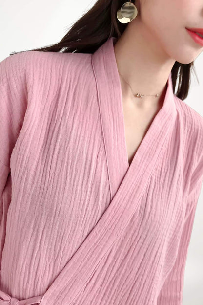 Kimono en gaze de coton rose, avec une texture plissée, porté par une femme au cou légèrement incliné