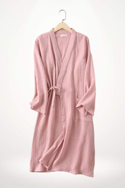 Kimono en gaze de coton rose, avec des manches larges, noué à la taille, suspendu sur un cintre