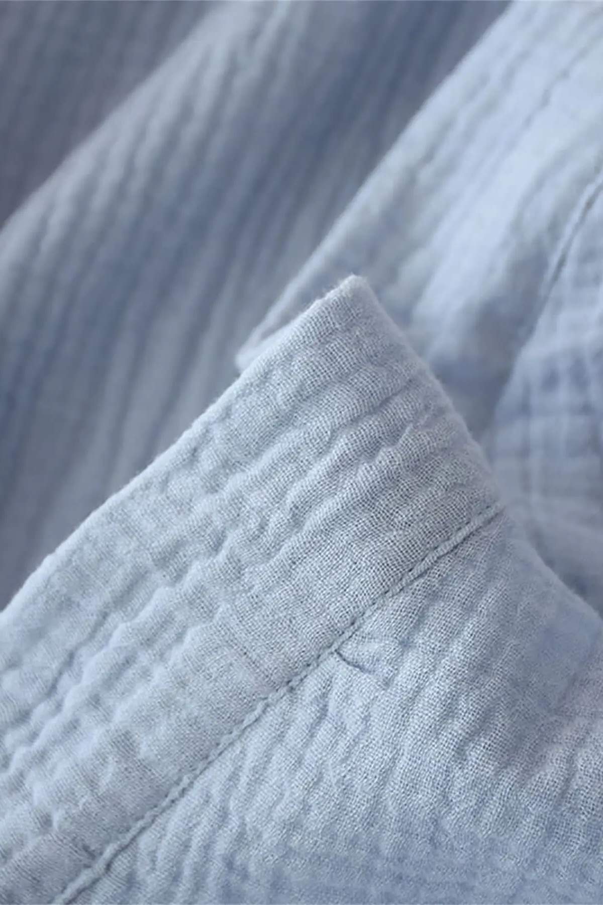 Tissu en gaze de coton bleu clair avec un motif texturé et des finitions soignées, évoquant un style japonais
