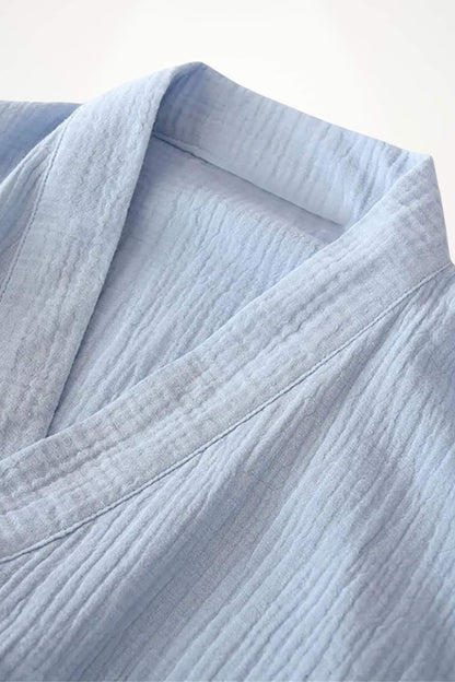 Détail d'un kimono en gaze de coton bleu clair, avec une texture plissée et des coutures délicates