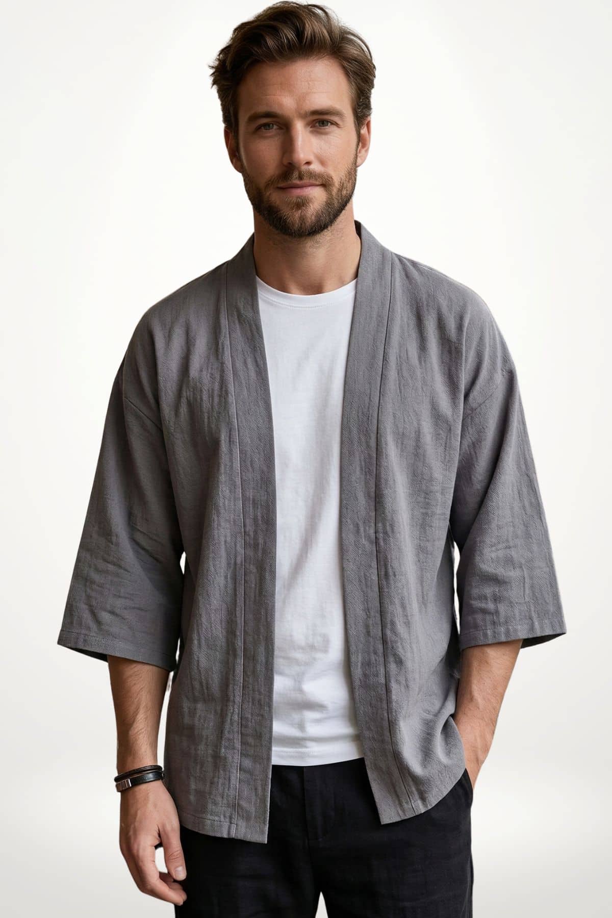 Homme portant un kimono moderne gris avec un t-shirt blanc, dans un décor minimaliste et lumineux