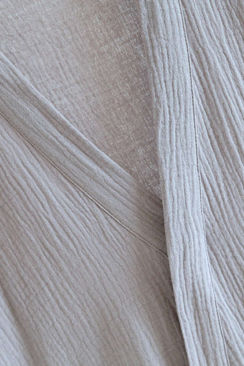 Tissu léger de couleur beige avec des motifs texturés, évoquant un kimono confortable et doux