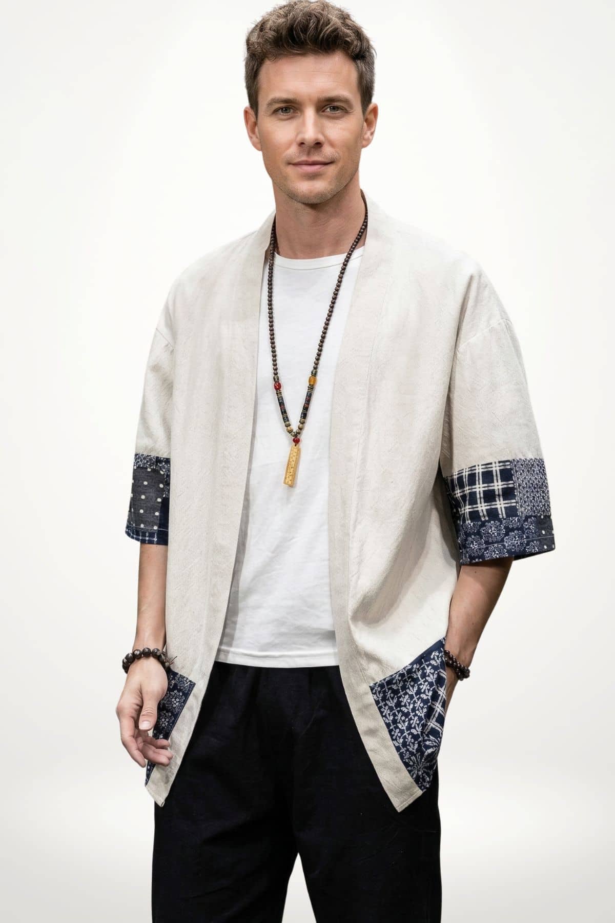 Homme portant un kimono beige avec des manches à motifs bleus, posé sur un fond blanc