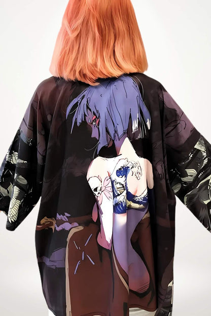 Kimono léger aux motifs colorés, affichant des illustrations graphiques sur un fond sombre, porté par une femme aux cheveux roux