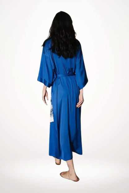 Femme vue de dos portant un kimono long bleu vif avec des manches larges et une ceinture assortie