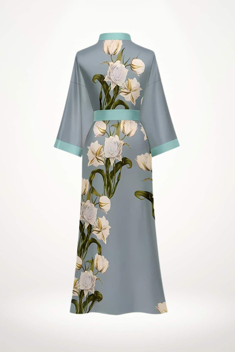 Kimono long en tissu léger, bleu clair avec des motifs floraux blancs et verts, ceinturé à la taille