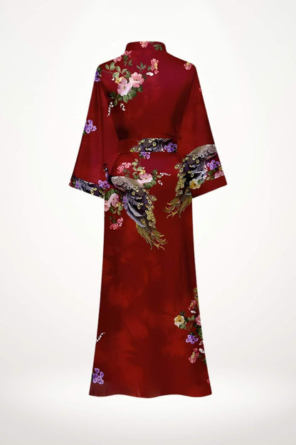 Kimono long en satin rouge avec motifs floraux colorés et détails de paon, évoquant l'élégance nocturne