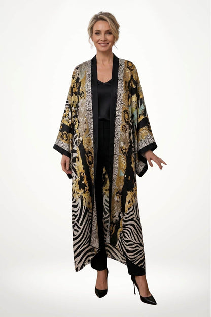 Femme souriante portant un kimono long noir et doré avec motifs animaliers sur fond blanc