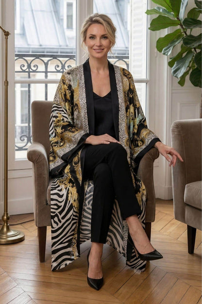 Femme assise dans un kimono long aux motifs dorés et zébrés, sur un fauteuil en velours dans un décor lumineux