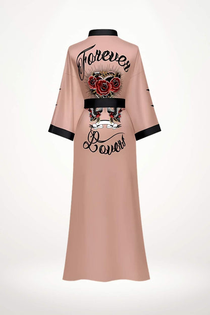 Kimono long en satin rose avec motifs floraux, col noir et inscription stylisée au dos