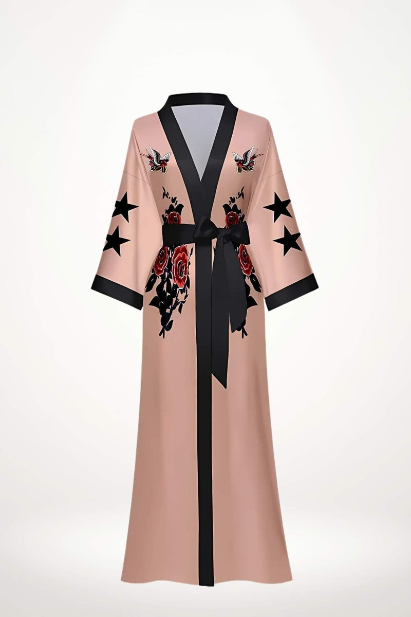 Kimono long en satin rose avec motifs de roses rouges et étoiles noires, ceinturé par un ruban noir
