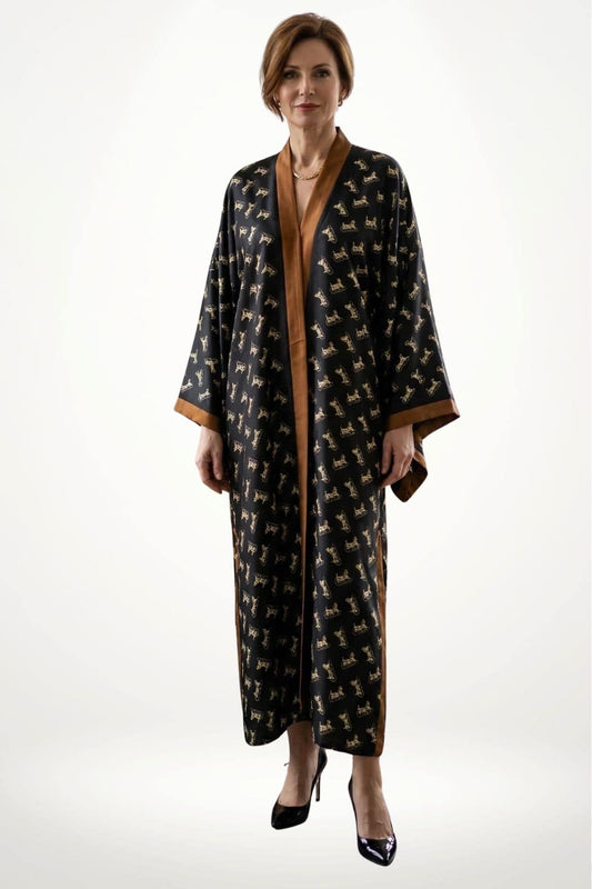Kimono long noir avec motifs dorés, bordure en satin marron, porté par une femme en talons hauts