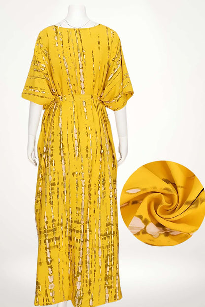 Kimono long en tissu jaune avec motifs dorés, offrant une coupe ample et fluide pour un style élégant