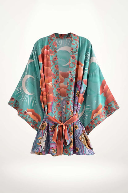 Kimono mi-long en tissu turquoise avec motifs floraux roses et détails colorés, évoquant un style bohème et doux