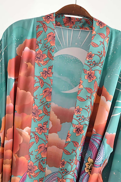 Kimono mi-long aux motifs floraux colorés sur fond turquoise, évoquant une ambiance bohème et douce