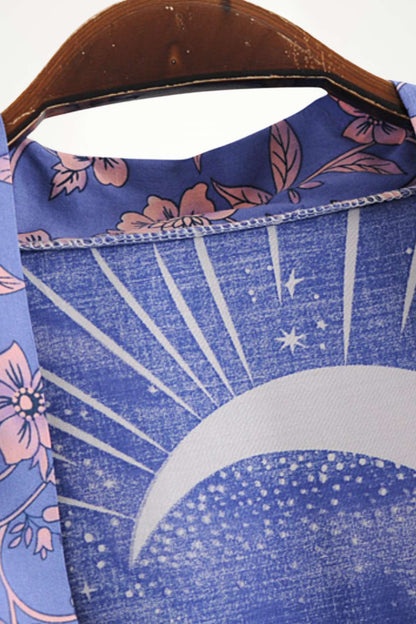 Détail d'un kimono mi-long avec motifs floraux roses sur fond bleu et design de lune stylisé