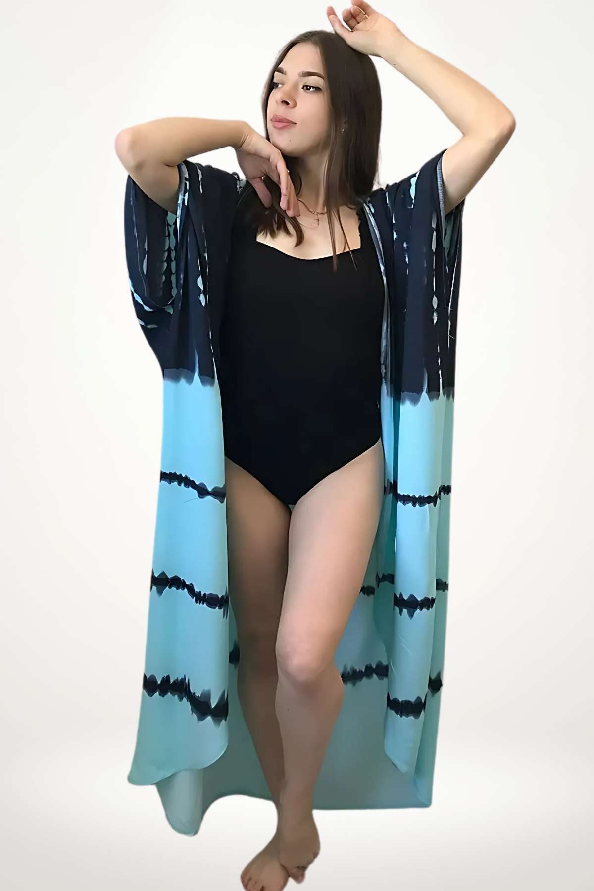 Femme en kimono bleu dégradé, debout avec une posture élégante, sur fond neutre, mettant en valeur le tissu léger