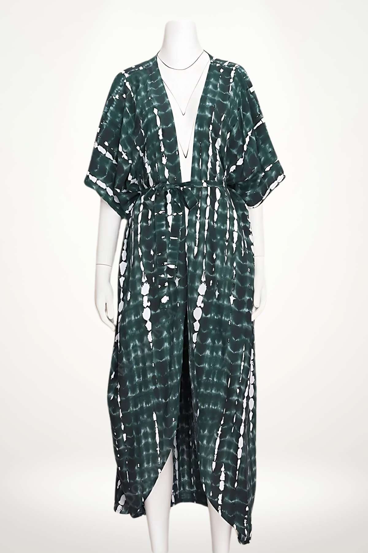 Kimono long en tissu vert foncé avec motifs blancs, ceinturé à la taille, sur fond clair