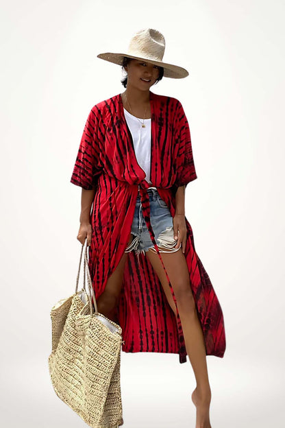 Femme souriante portant un kimono rouge à motifs, un t-shirt blanc, un short en denim et un chapeau de paille